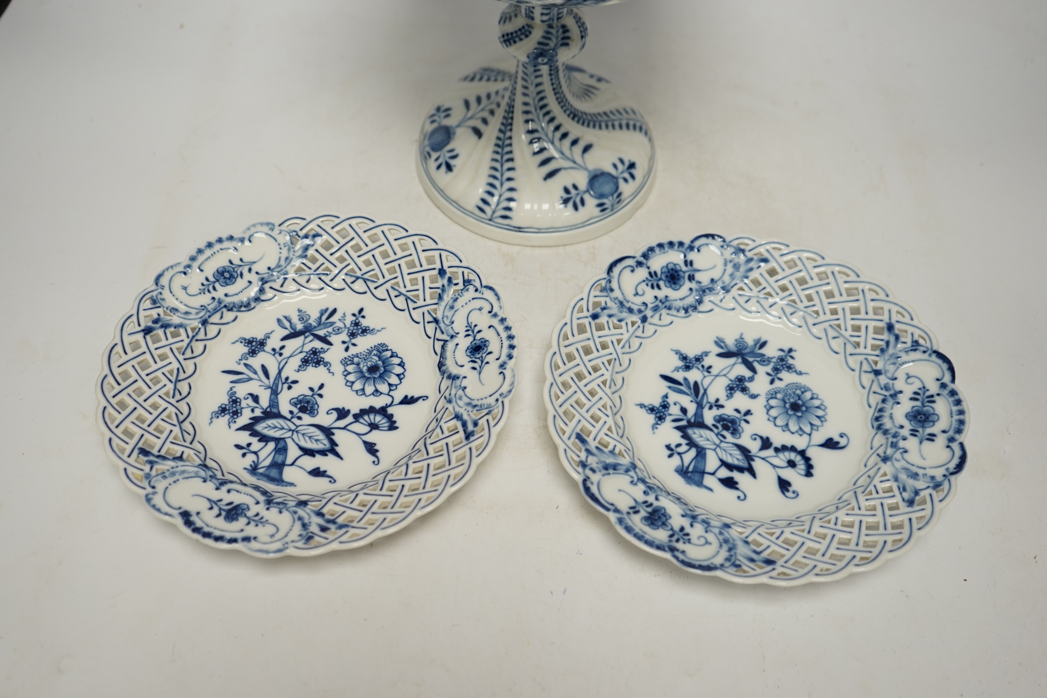 A late 19th Meissen blue and white onion pattern dessert service, consisting of a pair of comports and twelve dishes, all with pierced borders, (14). Condition - poor to good, two plates with pieces of border missing, on